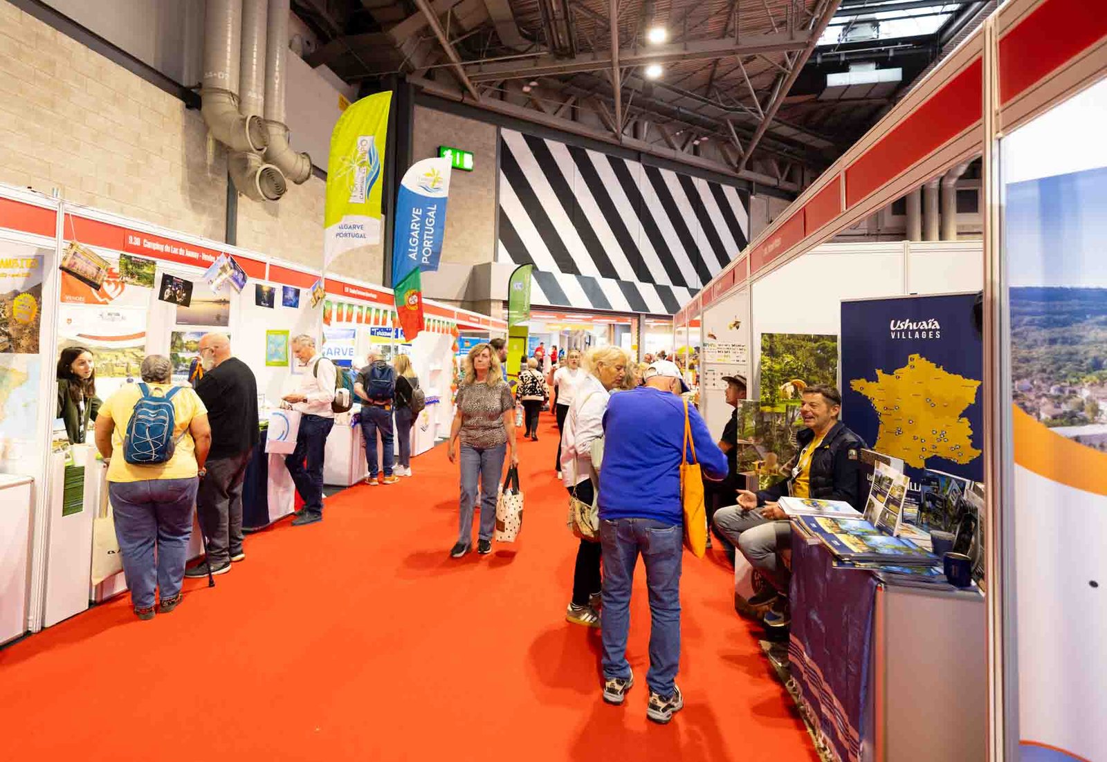 Allée des stands au salon caravaning — campings français en représentation